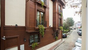 A two-story building with a brown facade, large windows with iron railings, and a narrow street in front. - Berce Hotel (Istanbul)