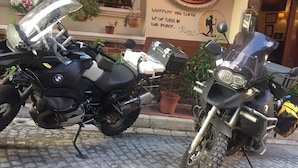 Two BMW motorcycles parked in front of a hotel with a sign that reads "Berce Hotel" and a quote by Rumi. - Berce Hotel (Istanbul)