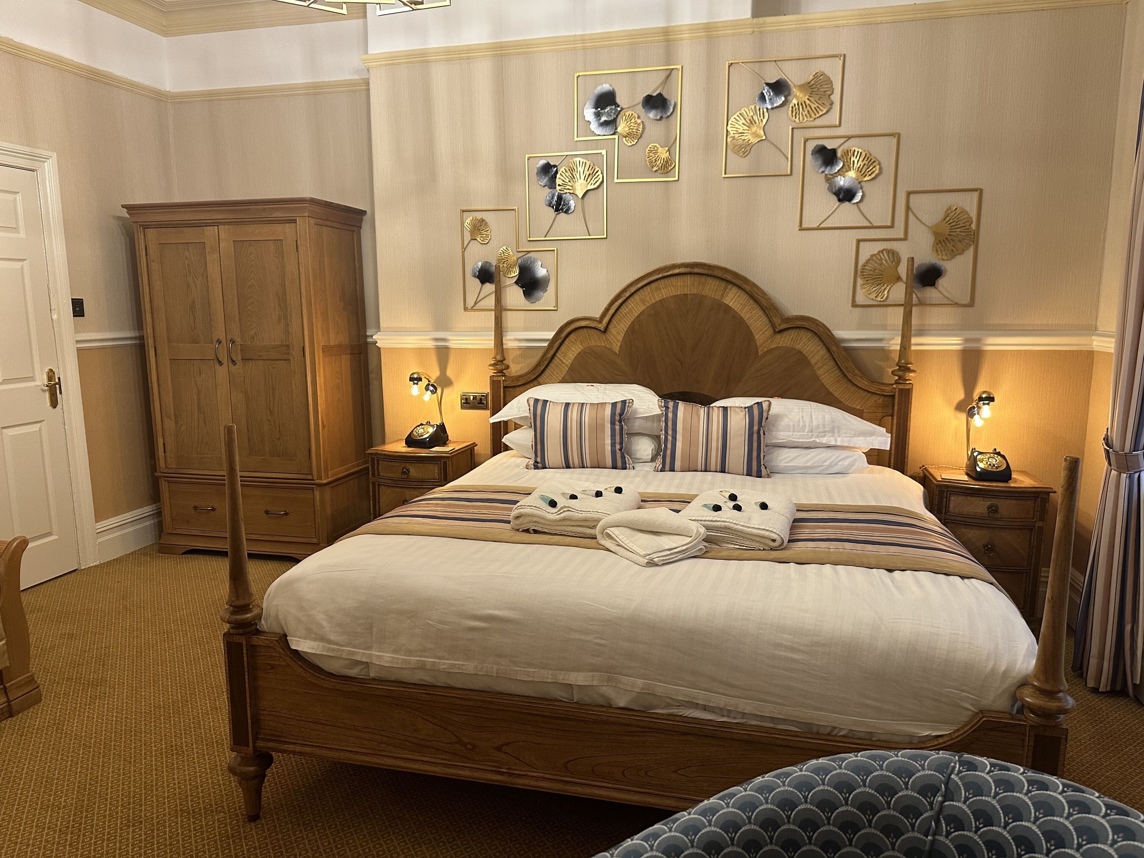 Un dormitorio ordenado con una cama grande de madera, mesitas de noche a juego y un armario de madera.