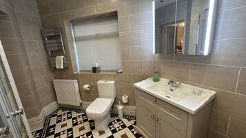Un baño con inodoro, lavabo y espejo.