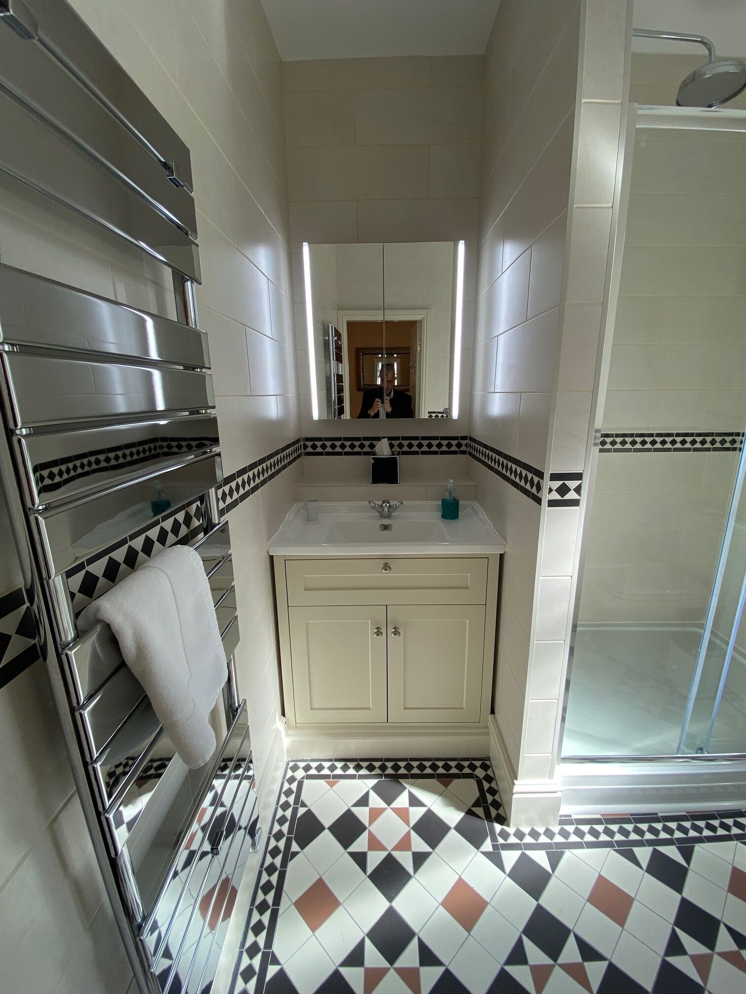 Un baño con ducha, lavamanos y espejo.