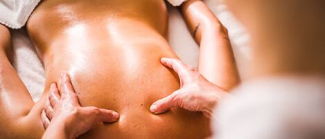 Gros plan d’un massage effectué sur le dos d’une personne.