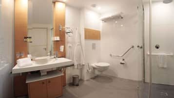 Une salle de bain moderne avec une douche à parois de verre, un lavabo blanc et des toilettes.