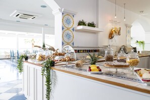 Un bufé de desayuno con diversas opciones de comida y un interior moderno y luminoso.