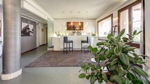 A modern kitchen with a bar area, large windows, and a central island. - Hotel Alba Roma (Rome)