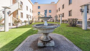 A courtyard with a central fountain, surrounded by a building with balconies and windows. - Hotel Alba Roma (Rome)