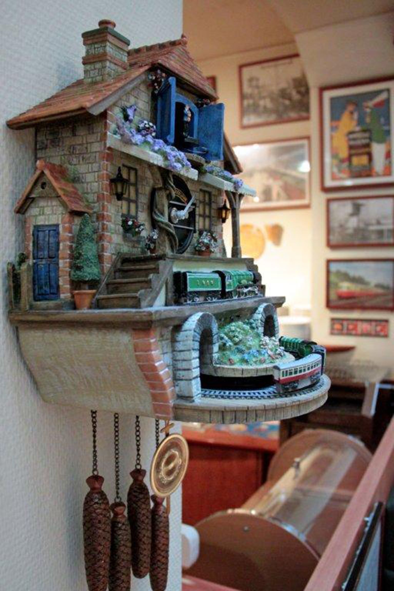 A model house with a chimney, a blue door, and a small tree on the left side.