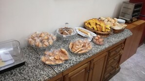 A buffet counter with various food items including bread, pastries, and eggs. - Hotel Dom Vilas (Braga)