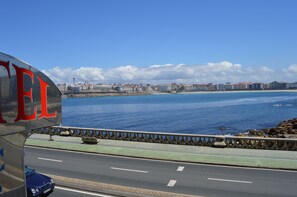 A coastal cityscape with a prominent bridge and a body of water. - Cristal 2 (A Coruña)
