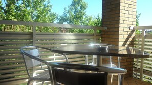 An outdoor patio with a metal table and chairs, a brick wall, and a wooden fence. - Antica Ravenna Residence (Ravenna)