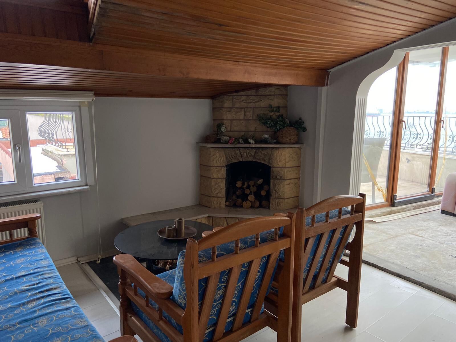 A cozy room with a stone fireplace, a round table, and two wooden chairs.
