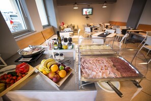 A buffet setup with various food items and condiments.