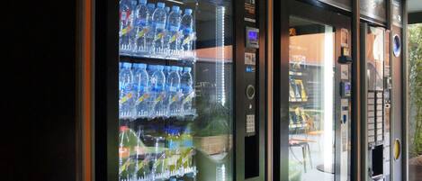 Una hilera de máquinas expendedoras con diversas bebidas y aperitivos.