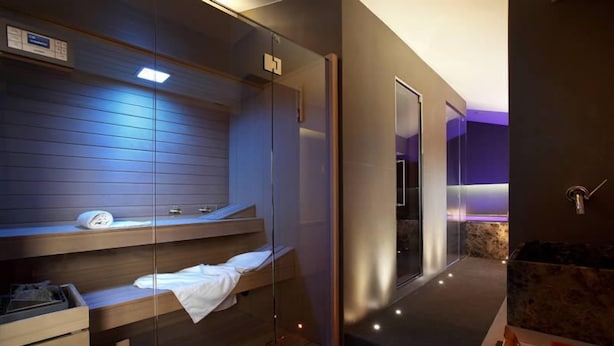 A modern spa room with a glass-enclosed sauna, wooden benches, and a marble bath area. - Villa Luisa (Todi)