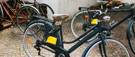 Una bicicleta con una etiqueta amarilla estacionada sobre adoquines.