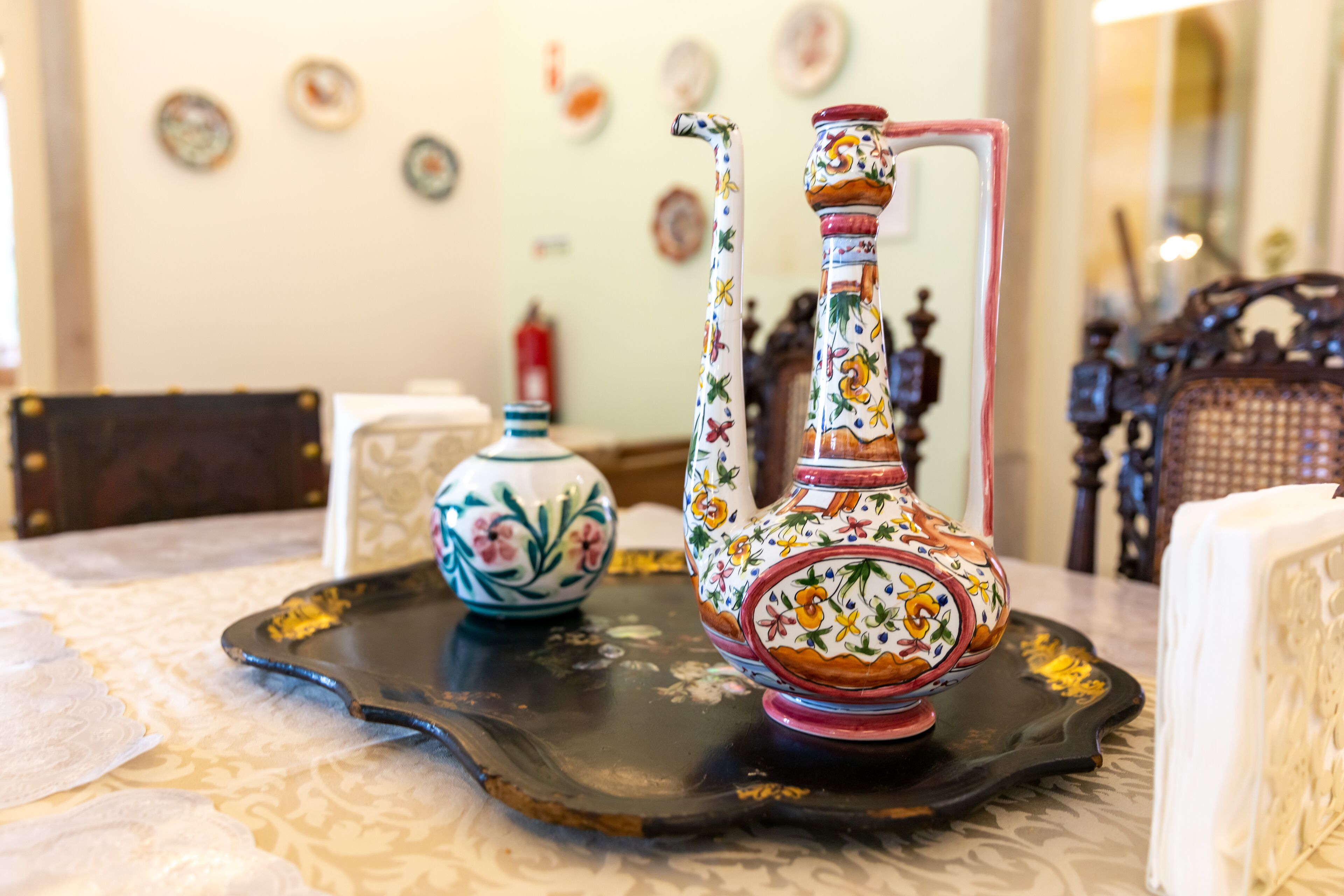 A table with a tray holding a decorative pitcher and a small vase.