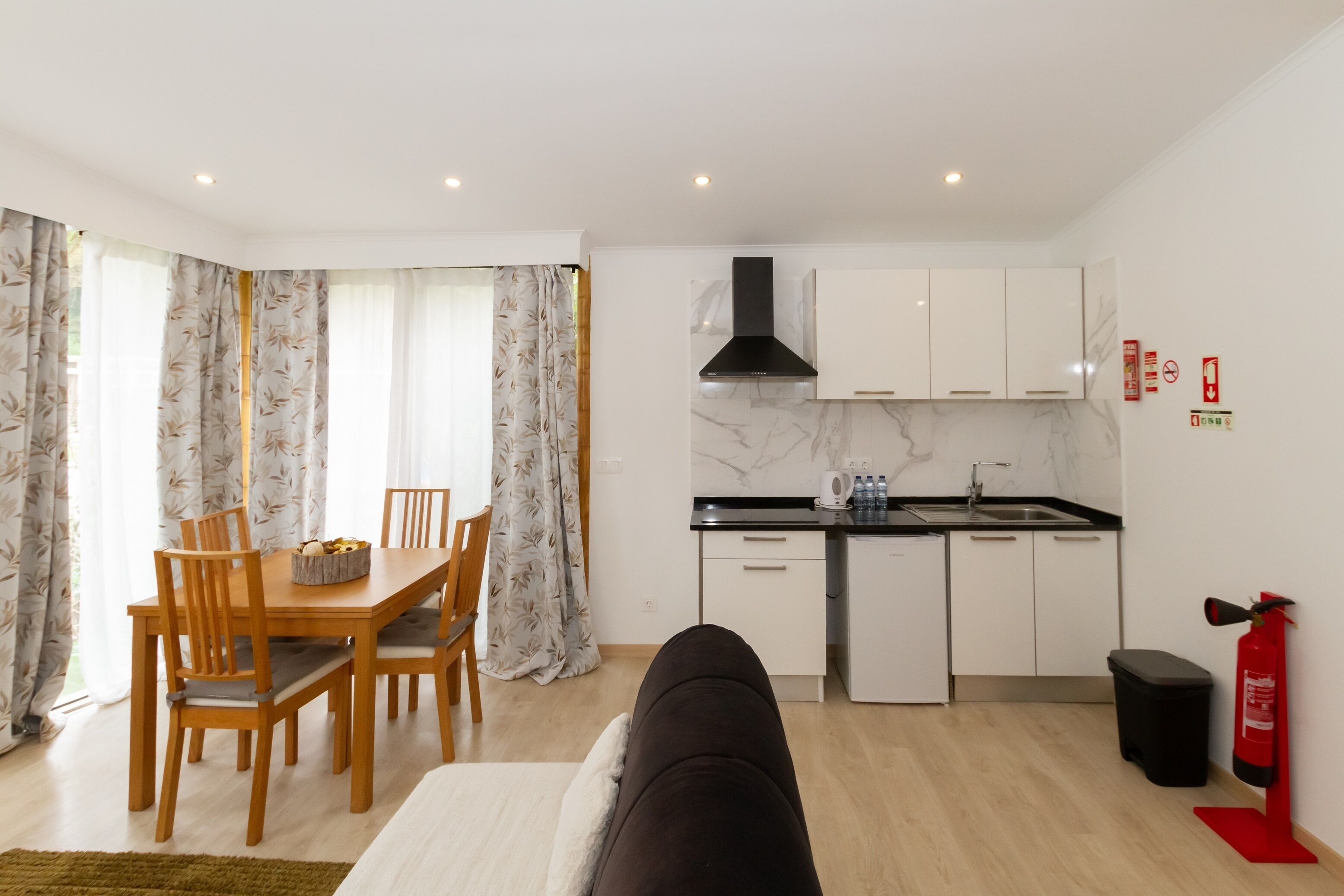 Un espacio habitable compacto con kitchenette, comedor y sofá.