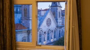 A room with a large window overlooking a historic building with a dome and clock tower. - Triada Hotel Taksim (Istanbul)