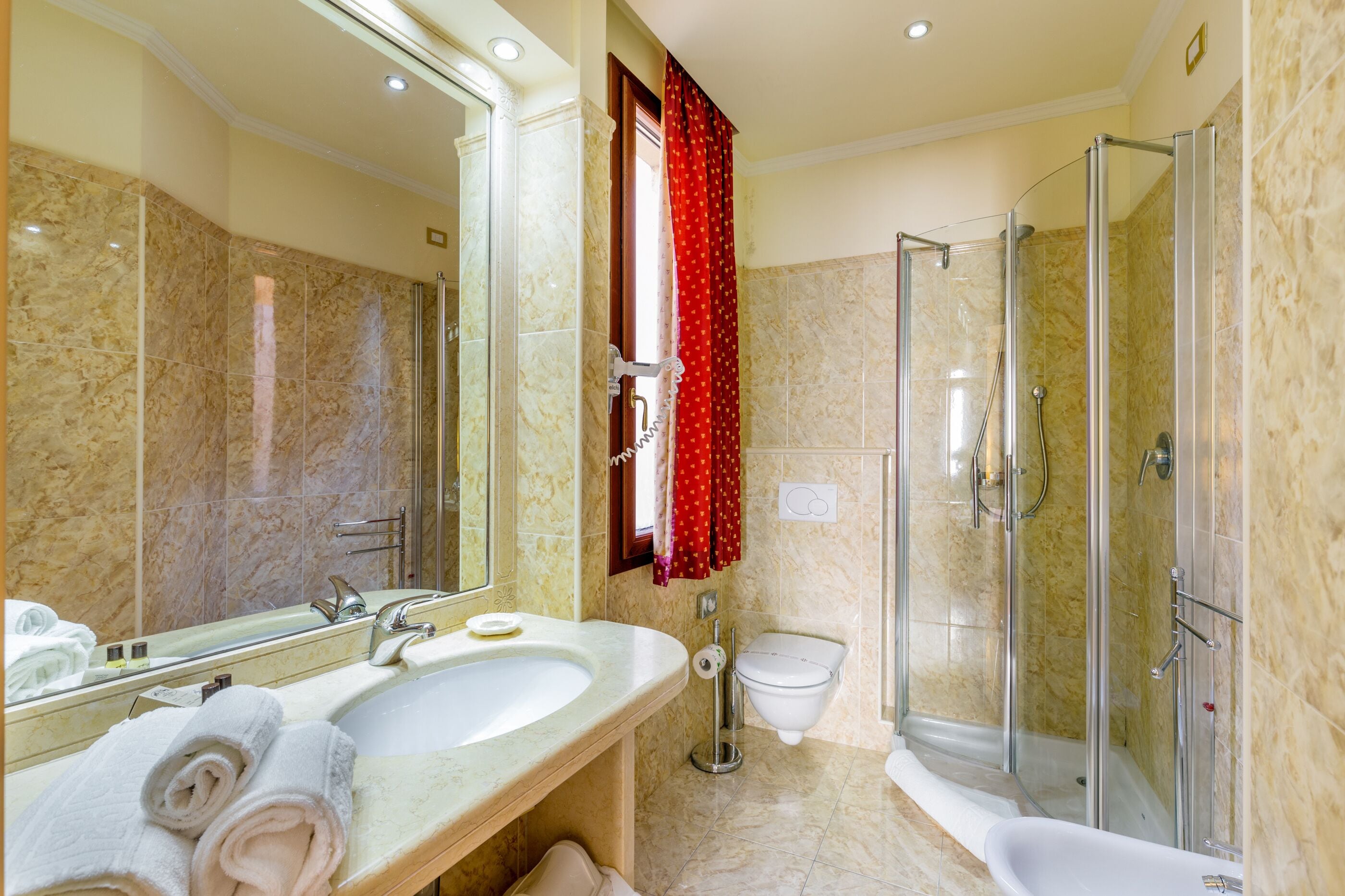 A bathroom with a large mirror, two sinks, a toilet, a shower, and a bathtub.