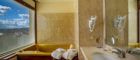 A modern bathroom with a bathtub, a large mirror, and a sink.