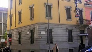 Un edifici de diversos pisos amb façana groga i part inferior gris.
