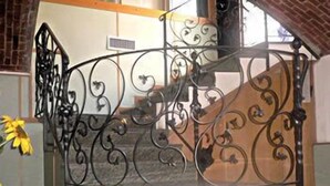 Una escala espirallada amb barana metàl·lica ornamentada a l'interior d'un edifici.
