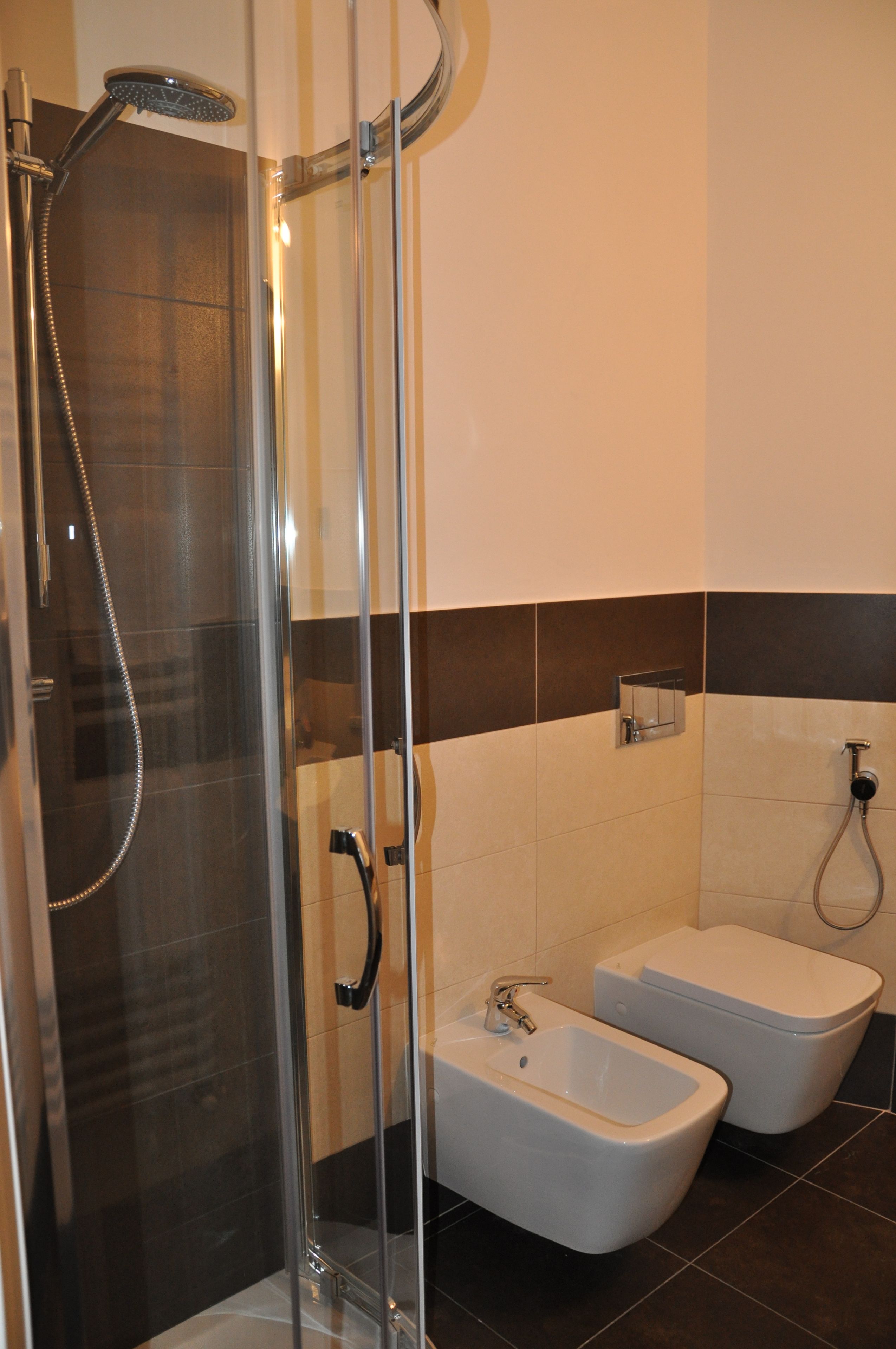 Ein modernes Badezimmer mit einer gläsernen Duschkabine, einem Bidet und einer Badewanne.