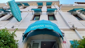 Fachada del Hotel Mangana con una entrada destacada y toldos.