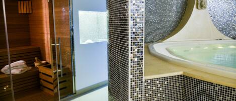 A spa area with a wooden sauna, a glass-enclosed shower, and a tiled bathtub.