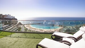 Un balcon avec vue sur une plage et l’océan.