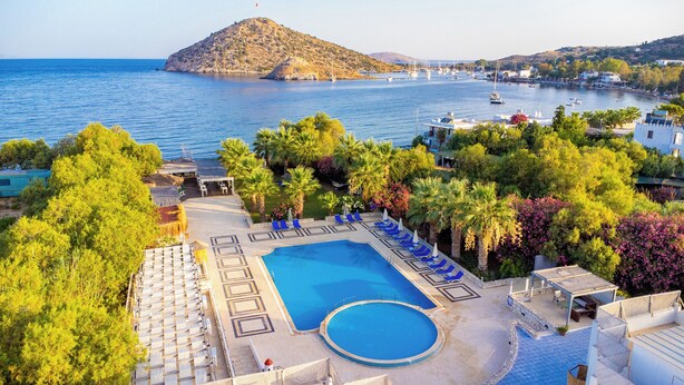 A resort with a large pool, lounge chairs, and a view of the sea. - Ladonia Hotels Zemda Gümüşlük (Bodrum)