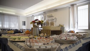 Una mesa de buffet con diferentes alimentos y un jarrón decorativo con flores.