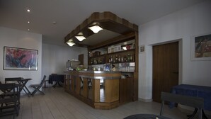 Una cocina moderna con barra, armarios de madera y piso de baldosas.