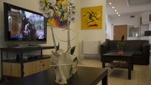 Una sala de estar con televisión, mesa de centro y sofá.