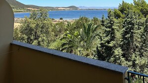 Uma varanda com vista para um lago e colinas ao redor.