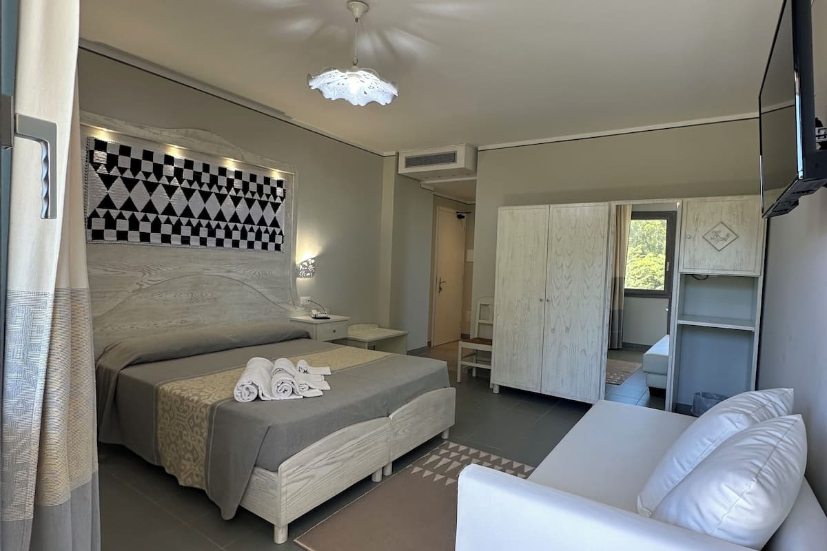 Une chambre à coucher moderne avec un lit, une table de chevet et un canapé blanc.