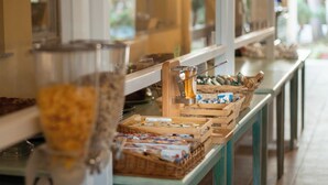 Disposição de buffet com diversos alimentos e um espremedor de sucos.