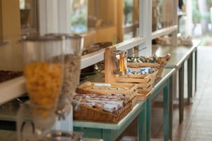 A buffet setup with various food items and a juicer.