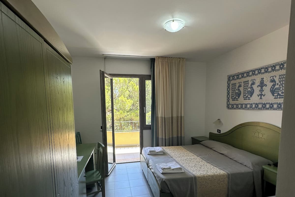 Une chambre d’hôtel avec deux lits, un bureau et une armoire.