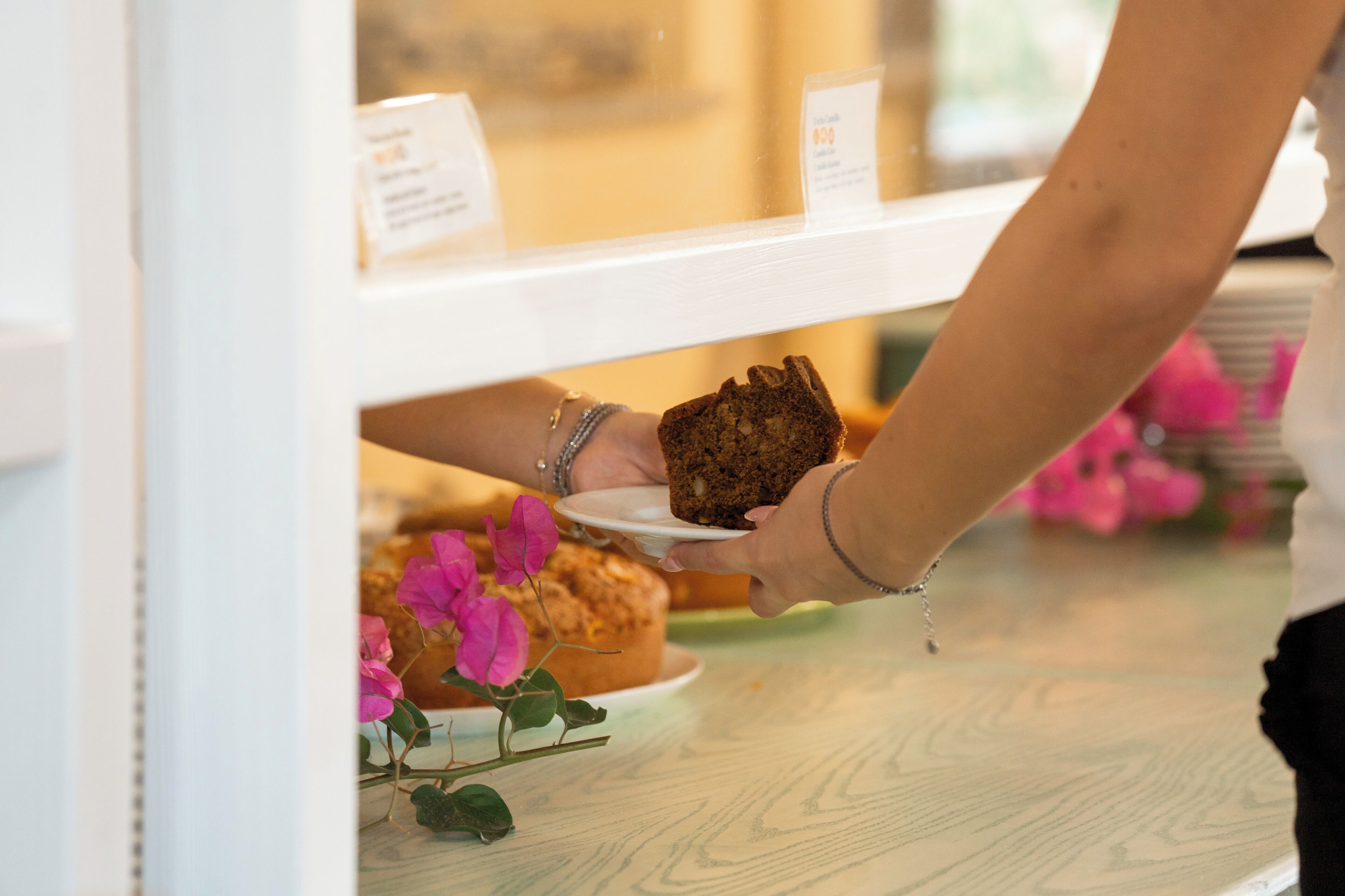 A person receiving a cake from a display case.