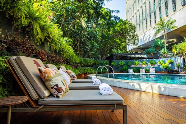 Alberca al aire libre y camastros 