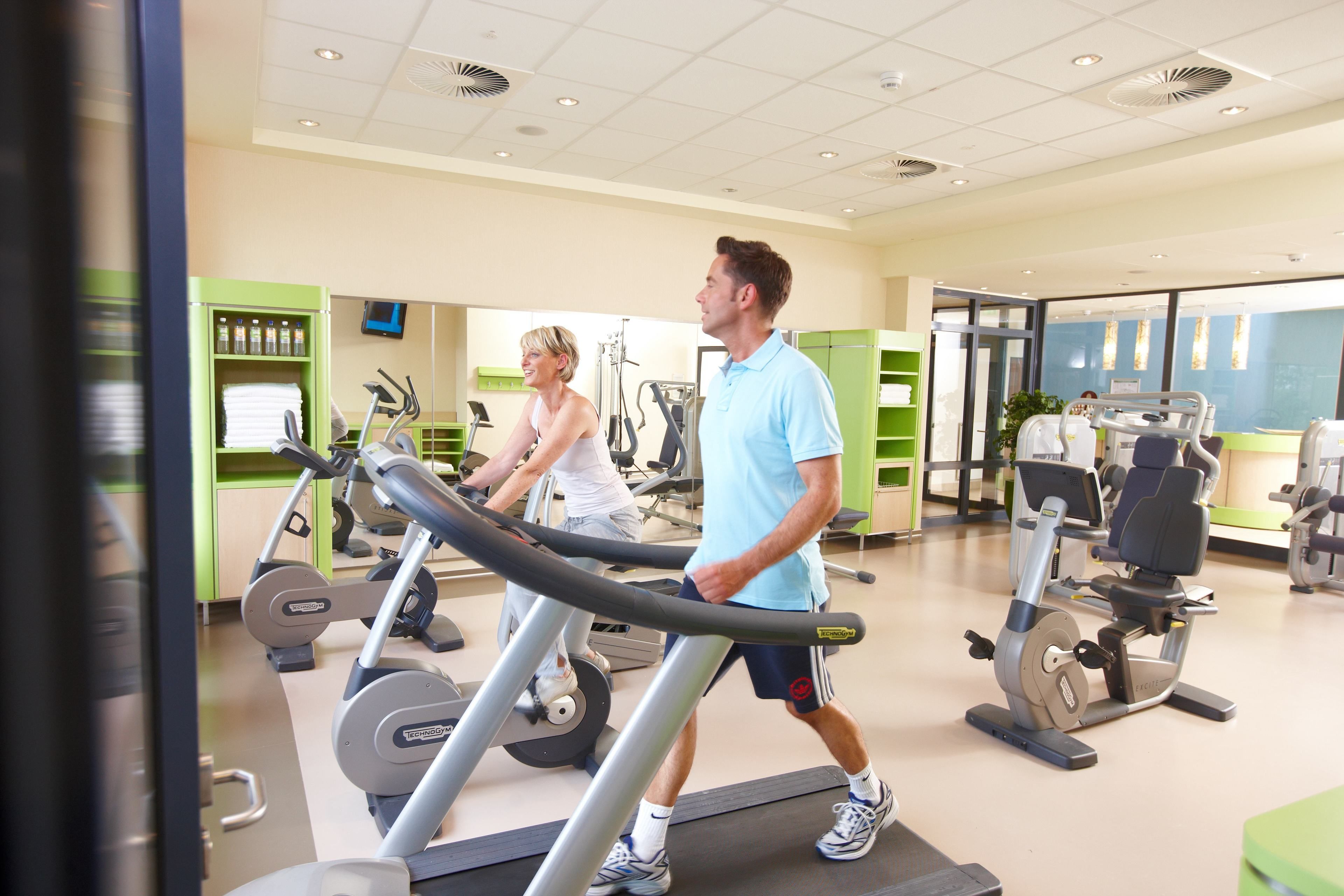 A gym with treadmills, exercise bikes, and weight machines.