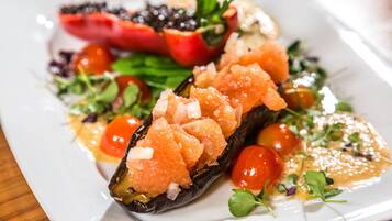 A plate of food with salmon, cherry tomatoes, and greens.
