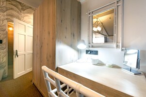 A bathroom with a wooden vanity, a mirror, a towel rack, and a shower area.
