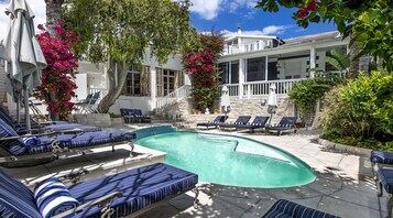A poolside area with lounge chairs and a swimming pool.
