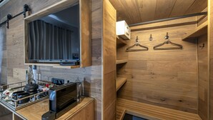 Cozinha moderna com armários de madeira, micro-ondas embutido e chaleira no balcão.