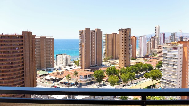 A high-rise building complex with multiple floors, a clear view of the sea, and a mix of residential and commercial buildings. - Apartamentos Dynastic Rooms (Benidorm)