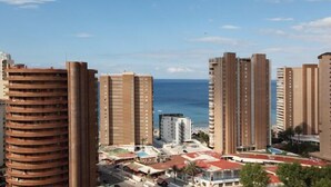 A high-rise building complex with multiple floors, a clear view of the sea, and a mix of residential and commercial buildings. - Apartamentos Dynastic Rooms (Benidorm)