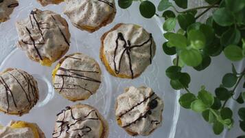 A tray of cookies with chocolate drizzle, placed on a clear glass plate.