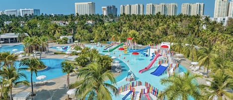 Un parc aquatique avec des toboggans et des piscines, entouré de palmiers et avec des bâtiments d'hôtel en arrière-plan.
